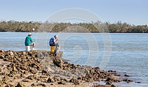 Three fishing, two men and a great blue heron Ardea herodias per